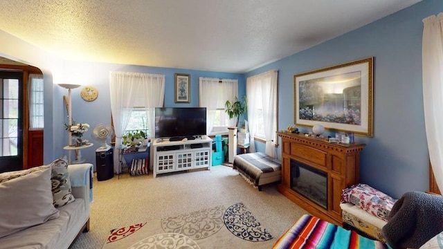 1862 Hooksett Rd, Hooksett, NH 03106 - living room featuring healthy amount of natural light, carpet flooring, a glass covered fireplace, and a textured ceiling