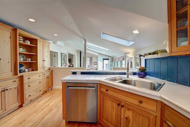 520 Washington Rd, Rye, NH 03870 - kitchen featuring dishwasher, a sink, a skylight, light wood-style flooring, and vaulted ceiling