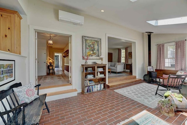 520 Washington Rd, Rye, NH 03870 - sitting room featuring a wall mounted AC, a skylight, healthy amount of natural light, baseboards, and vaulted ceiling