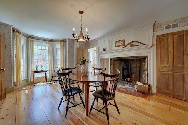 520 Washington Rd, Rye, NH 03870 - dining room featuring a chandelier, light wood-style floors, crown molding, and a fireplace
