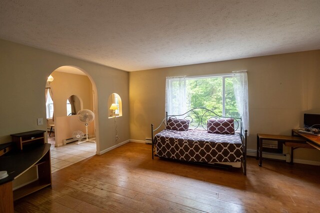 11 Henry Dr, Effingham, NH 03882 - bedroom with hardwood / wood-style flooring, a textured ceiling, arched walkways, baseboards, and a baseboard heating unit