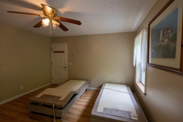 11 Henry Dr, Effingham, NH 03882 - unfurnished bedroom featuring baseboards, wood finished floors, ceiling fan, and a textured ceiling