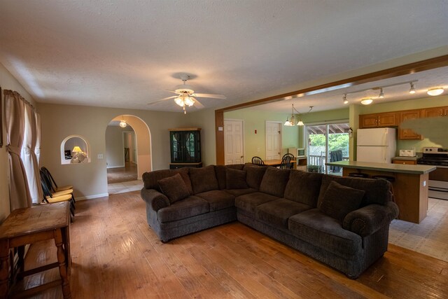 11 Henry Dr, Effingham, NH 03882 - living area featuring arched walkways, light wood-type flooring, ceiling fan, and baseboards