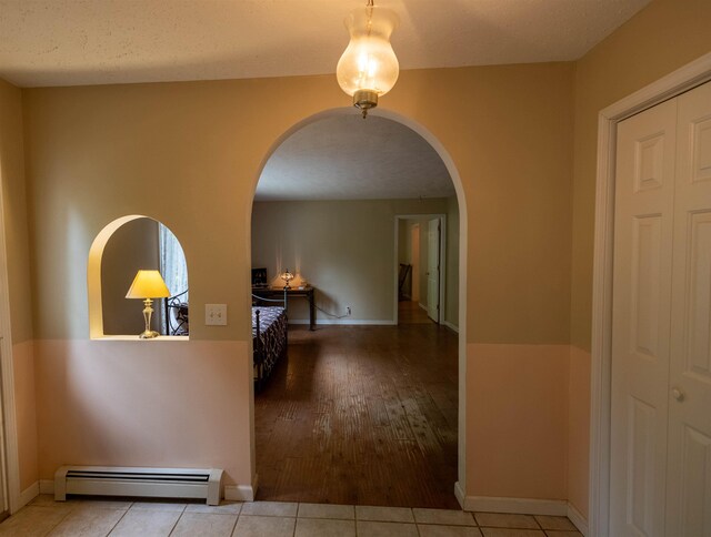 11 Henry Dr, Effingham, NH 03882 - corridor with a baseboard heating unit, arched walkways, wood finished floors, and baseboards