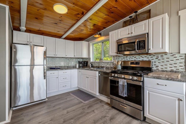 235 Pleasant View Dr, North Hero, VT 05474 - kitchen featuring stainless steel appliances, a sink, wood ceiling with exposed beams, white cabinets, and tasteful backsplash