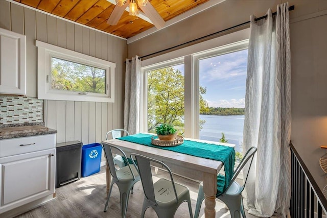 235 Pleasant View Dr, North Hero, VT 05474 - dining room with wood ceiling, a ceiling fan, a water view, light wood-style flooring, and wood walls