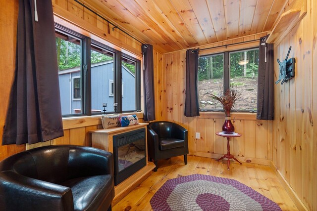 239 NE Pond Rd, Milton, NH 03851 - sitting room with healthy amount of natural light, wood-type flooring, wooden ceiling, and wood walls