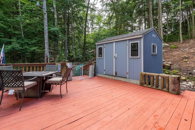 239 NE Pond Rd, Milton, NH 03851 - deck featuring outdoor dining space, an outbuilding, and view of scattered trees