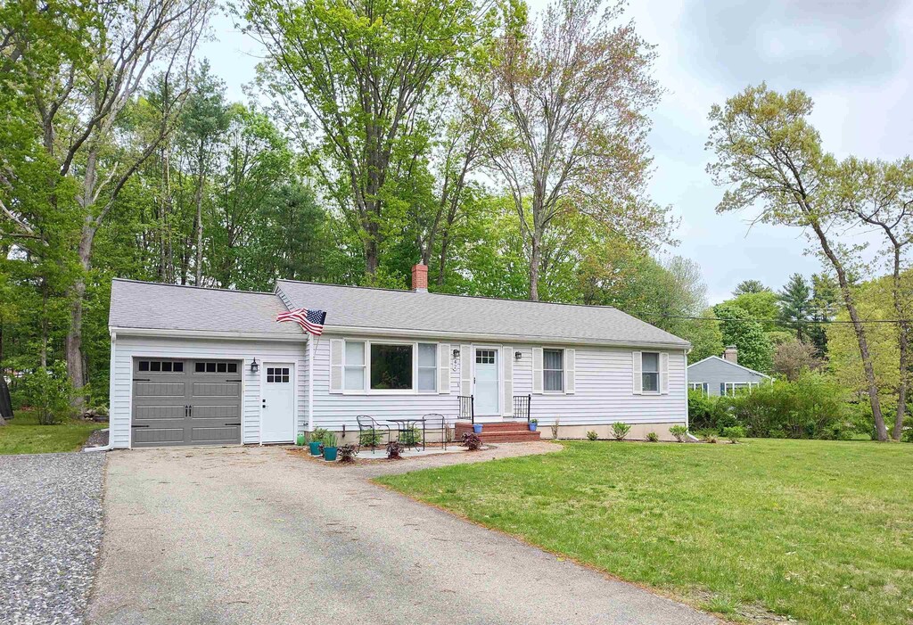 42 Pinewood Dr, Somersworth, NH 03878 - single story home with an attached garage, asphalt driveway, a front lawn, a chimney, and view of scattered trees