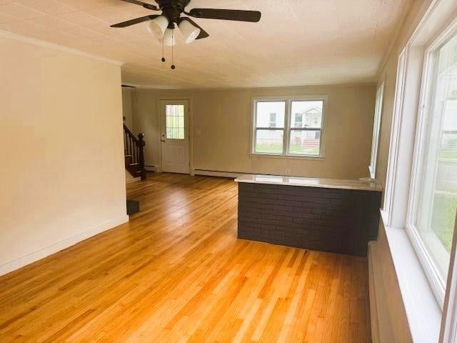 54 E Center St, Rutland City, VT 05701 - spare room featuring stairs, light wood-style floors, ceiling fan, ornamental molding, and baseboards