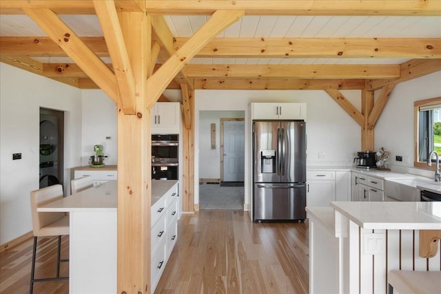 64 Atkins Farm Rd, Ferrisburgh, VT 05456 - kitchen featuring stainless steel appliances, a sink, a breakfast bar area, light countertops, and light wood-style floors