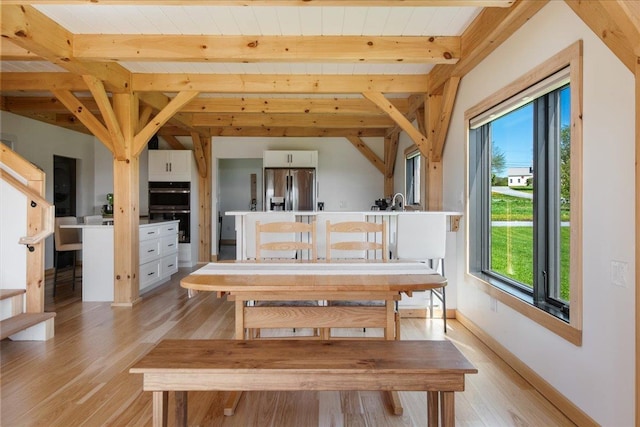 64 Atkins Farm Rd, Ferrisburgh, VT 05456 - dining area with light wood-style floors, healthy amount of natural light, wooden ceiling with exposed beams, and baseboards