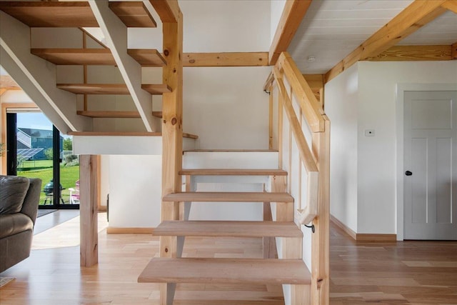 64 Atkins Farm Rd, Ferrisburgh, VT 05456 - stairway featuring baseboards, wood finished floors, and beam ceiling