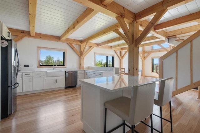 64 Atkins Farm Rd, Ferrisburgh, VT 05456 - kitchen with appliances with stainless steel finishes, a breakfast bar area, light countertops, beam ceiling, and a sink