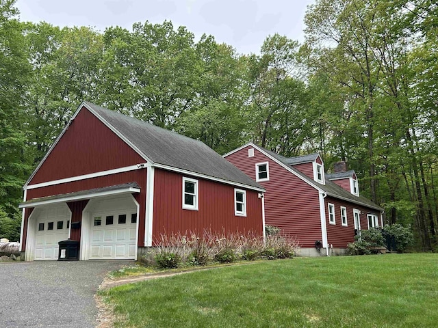 7 Juniper Ridge Rd, Exeter, NH 03833 - view of side of property with an outbuilding, a yard, roof with shingles, a garage, and view of scattered trees
