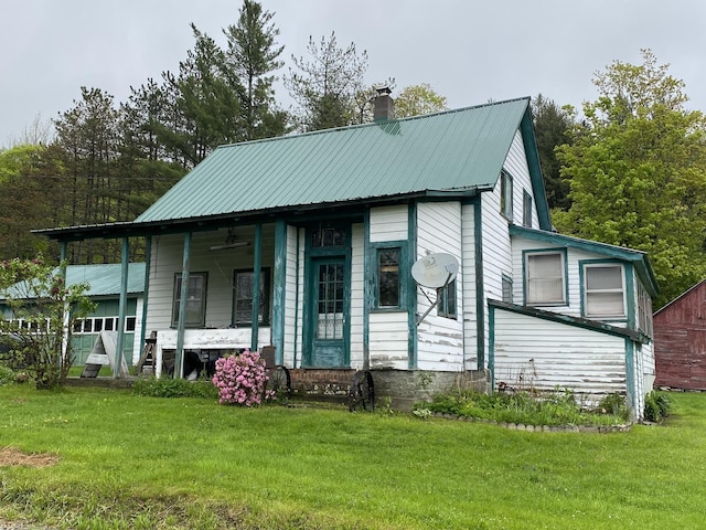 178 Parsons Rd, Wilmington, VT 05363 - view of front of house featuring a ceiling fan, a front yard, a chimney, covered porch, and metal roof