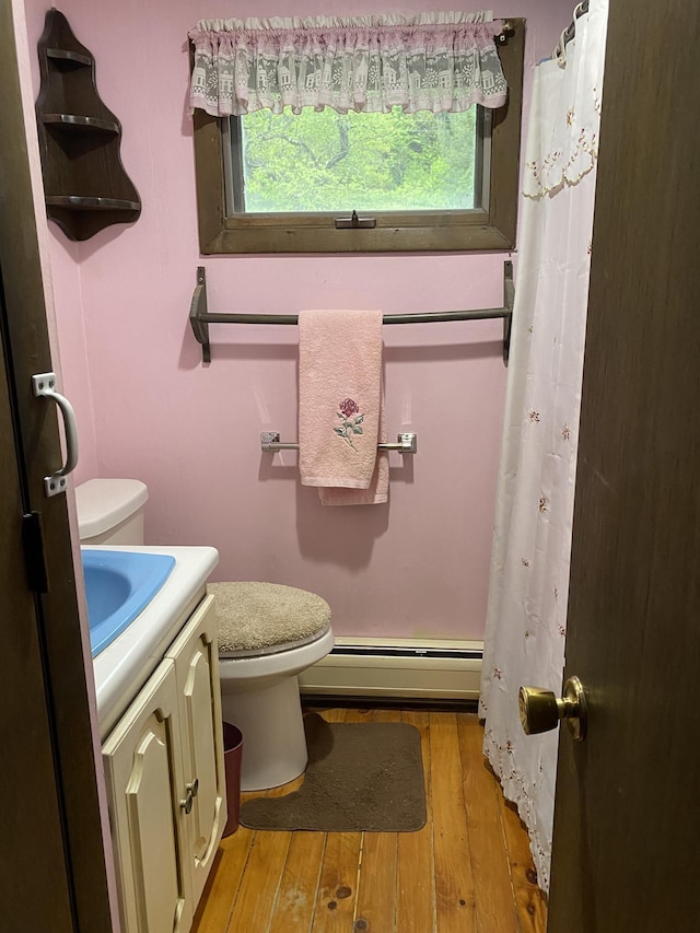 178 Parsons Rd, Wilmington, VT 05363 - bathroom featuring a baseboard heating unit, hardwood / wood-style floors, toilet, vanity, and curtained shower