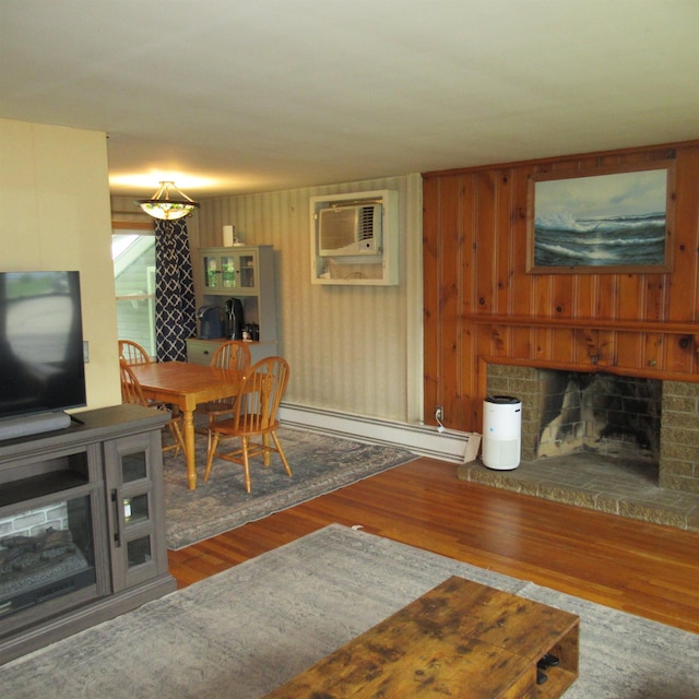 70 Forest Park Dr, Nashua, NH 03060 - living area with baseboard heating, a wall mounted AC, a fireplace, wood finished floors, and wooden walls