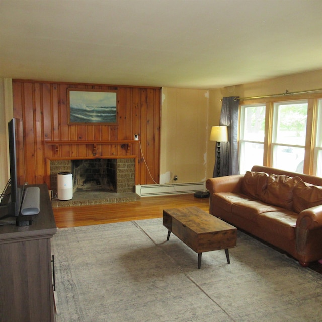 70 Forest Park Dr, Nashua, NH 03060 - living area featuring a baseboard radiator, a fireplace, wood finished floors, and wooden walls