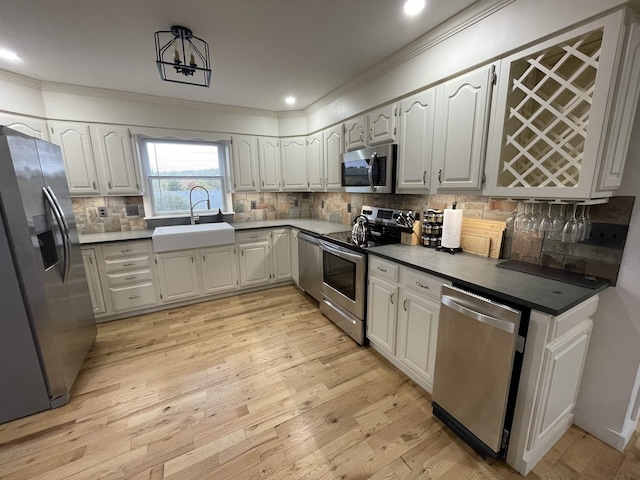 885 N St, Wells, VT 05774 - kitchen featuring stainless steel appliances, a sink, crown molding, light wood finished floors, and decorative backsplash