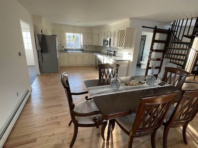 885 N St, Wells, VT 05774 - dining room featuring baseboard heating, light wood-style floors, and a barn door