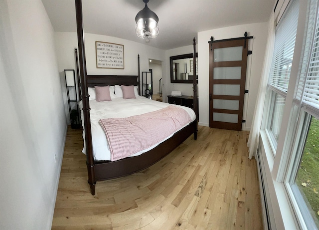 885 N St, Wells, VT 05774 - bedroom featuring a barn door, light wood-style flooring, and baseboards