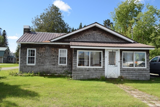 18 Bridge St, Lancaster, NH 03584 - view of front facade with a front lawn, a chimney, and metal roof