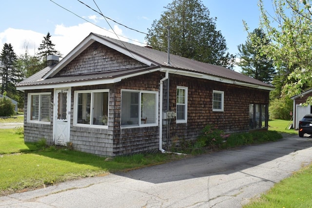 18 Bridge St, Lancaster, NH 03584 - view of front of property with a chimney, metal roof, and a front yard