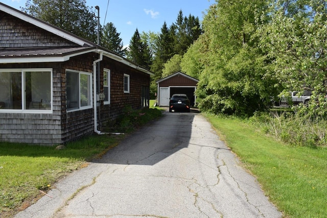 18 Bridge St, Lancaster, NH 03584 - view of side of property with a detached garage, an outdoor structure, and driveway