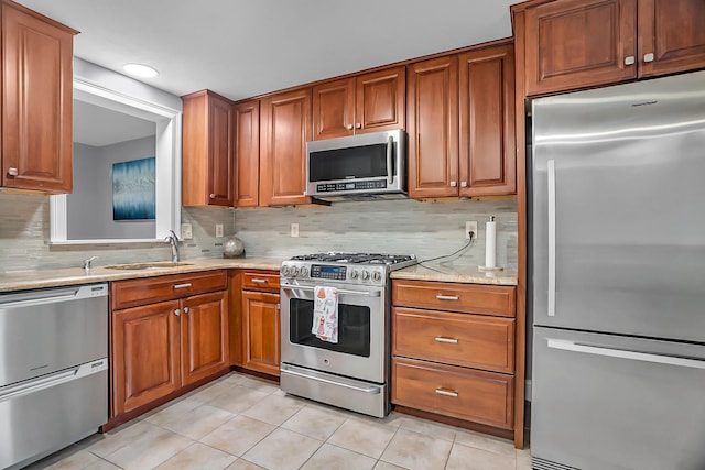 6 Swift Ln, Merrimack, NH 03054 - kitchen with appliances with stainless steel finishes, light tile patterned floors, tasteful backsplash, brown cabinetry, and light stone countertops