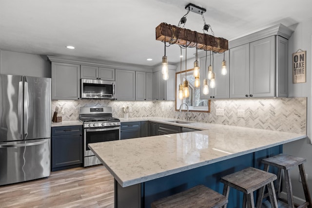 21 Regis Rd, Laconia, NH 03246 - kitchen featuring appliances with stainless steel finishes, a sink, gray cabinets, a peninsula, and recessed lighting