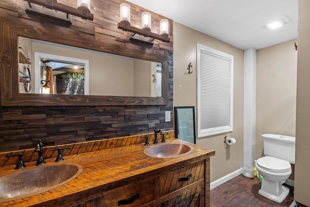 21 Regis Rd, Laconia, NH 03246 - bathroom featuring baseboards, wood finished floors, toilet, and double vanity