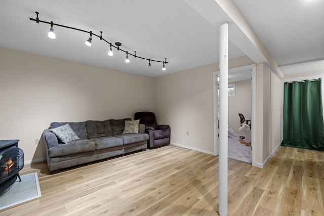 21 Regis Rd, Laconia, NH 03246 - living area with a wood stove, light wood-type flooring, and rail lighting