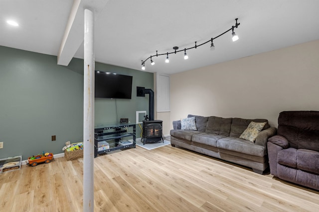 21 Regis Rd, Laconia, NH 03246 - living area featuring a wood stove, wood finished floors, baseboards, and rail lighting