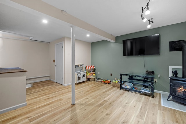 21 Regis Rd, Laconia, NH 03246 - rec room featuring a wood stove, wood finished floors, baseboards, and recessed lighting