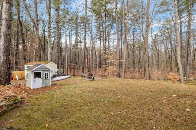 21 Regis Rd, Laconia, NH 03246 - view of green lawn featuring a fire pit and a wooded view