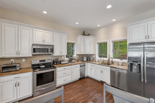 90 Paugus Park Rd, Laconia, NH 03246 - kitchen with stainless steel appliances, a sink, backsplash, white cabinets, and dark wood finished floors
