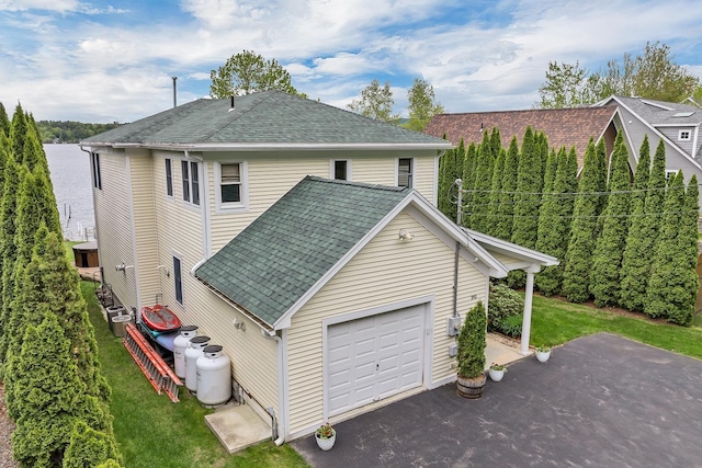 90 Paugus Park Rd, Laconia, NH 03246 - view of side of home with roof with shingles, a yard, and driveway