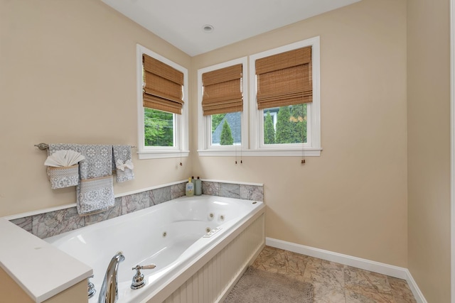 90 Paugus Park Rd, Laconia, NH 03246 - bathroom with a tub with jets, marble look tiles, and baseboards