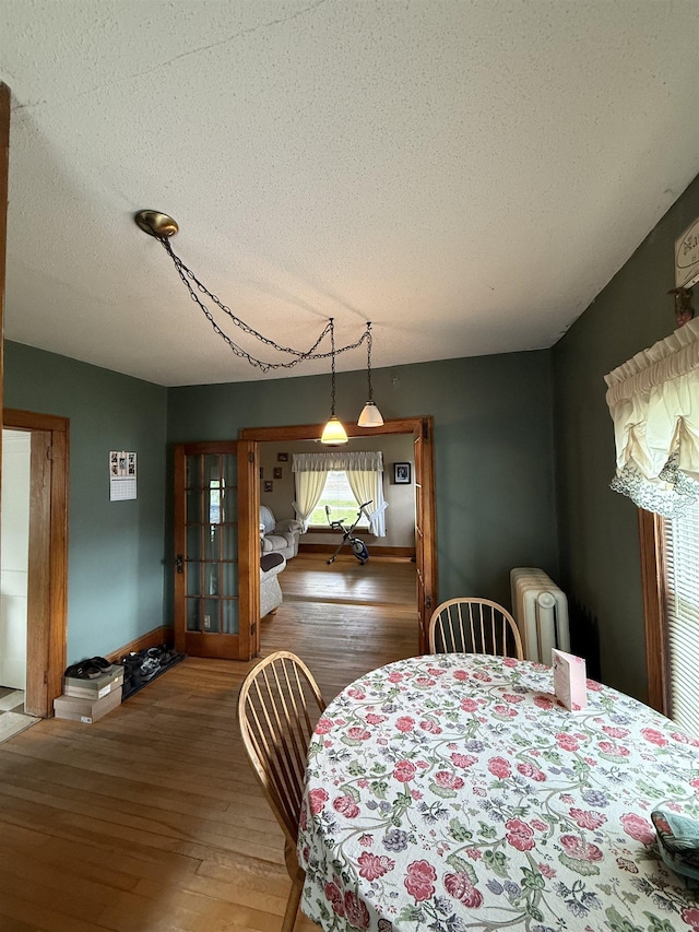 119 N Main St, Rutland City, VT 05701 - dining room featuring radiator heating unit, a textured ceiling, and wood finished floors