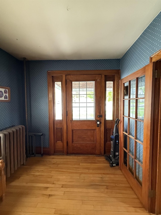 119 N Main St, Rutland City, VT 05701 - foyer entrance featuring radiator, wallpapered walls, and light wood-type flooring