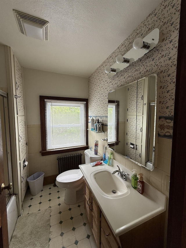 119 N Main St, Rutland City, VT 05701 - full bath with radiator, tile walls, toilet, an enclosed shower, and vanity