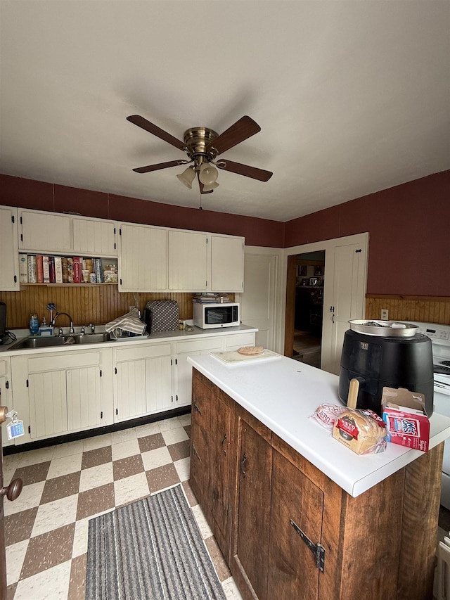 119 N Main St, Rutland City, VT 05701 - kitchen with a sink, white microwave, light flooring, light countertops, and ceiling fan