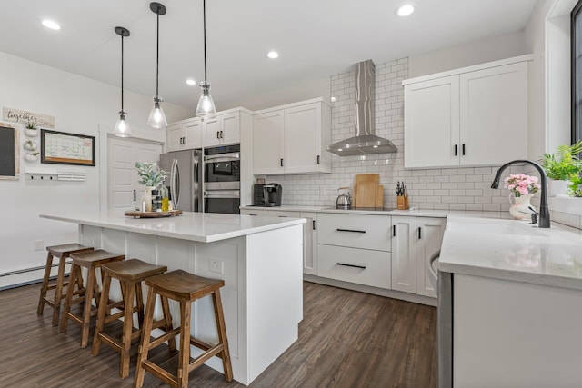 236 Macdowell Rd, Peterborough, NH 03458 - kitchen with wall chimney range hood, appliances with stainless steel finishes, a sink, dark wood-type flooring, and recessed lighting