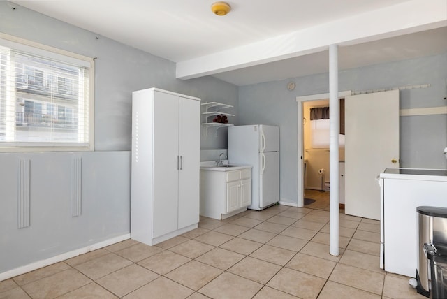 185 Kings Hwy, Hampton, NH 03842 - kitchen with freestanding refrigerator, light tile patterned floors, a sink, white cabinets, and open shelves