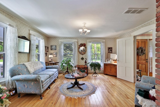 5100 Rte 100, Plymouth, VT 05056 - living room with wallpapered walls, light wood-style flooring, and a chandelier