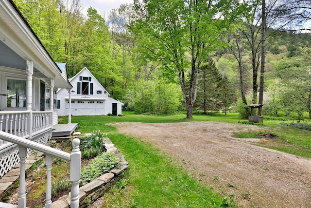 5100 Rte 100, Plymouth, VT 05056 - view of grassy yard with an outdoor structure, a detached garage, a wooded view, and driveway