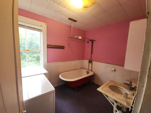 16 Northridge Rd, Burke, VT 05871 - bathroom with washer / dryer, a soaking tub, a wainscoted wall, and a sink
