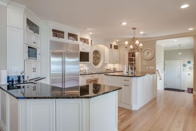 11 Clark Island Rd, Amherst, NH 03031 - kitchen with built in appliances, a sink, white cabinets, a peninsula, and light wood finished floors