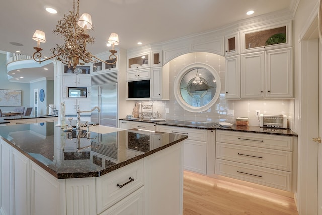 11 Clark Island Rd, Amherst, NH 03031 - kitchen featuring built in fridge, tasteful backsplash, white cabinetry, glass insert cabinets, and decorative light fixtures